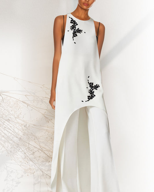 White dress with black floral embroidery on a white background